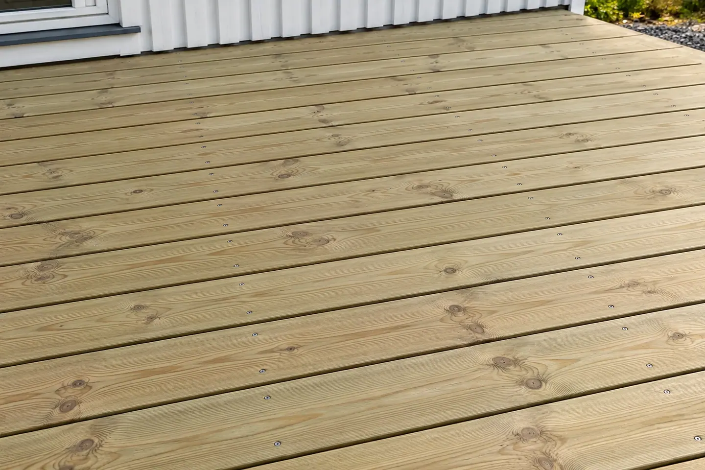 Trallbrädor längs husfasaden, tvärs över stödreglarna
